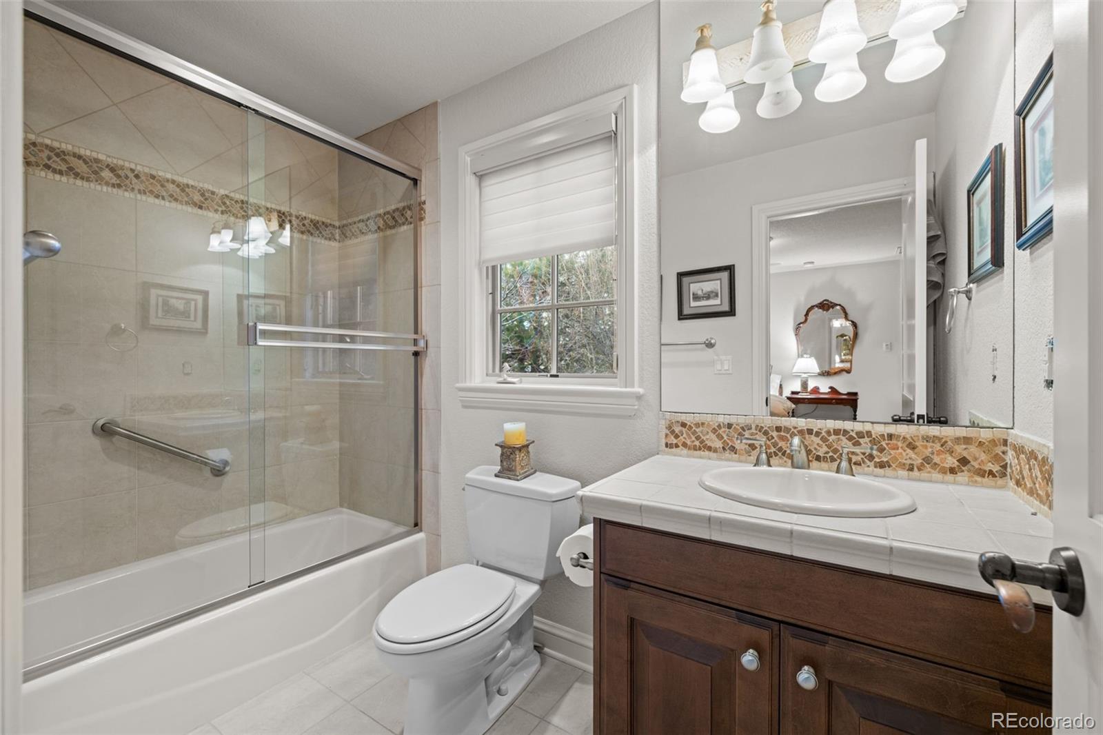 5 Redhawk Run Cherry Hills Village, CO 80113 - Photo 23 of 35 a bathroom with a sink a toilet a mirror and shower