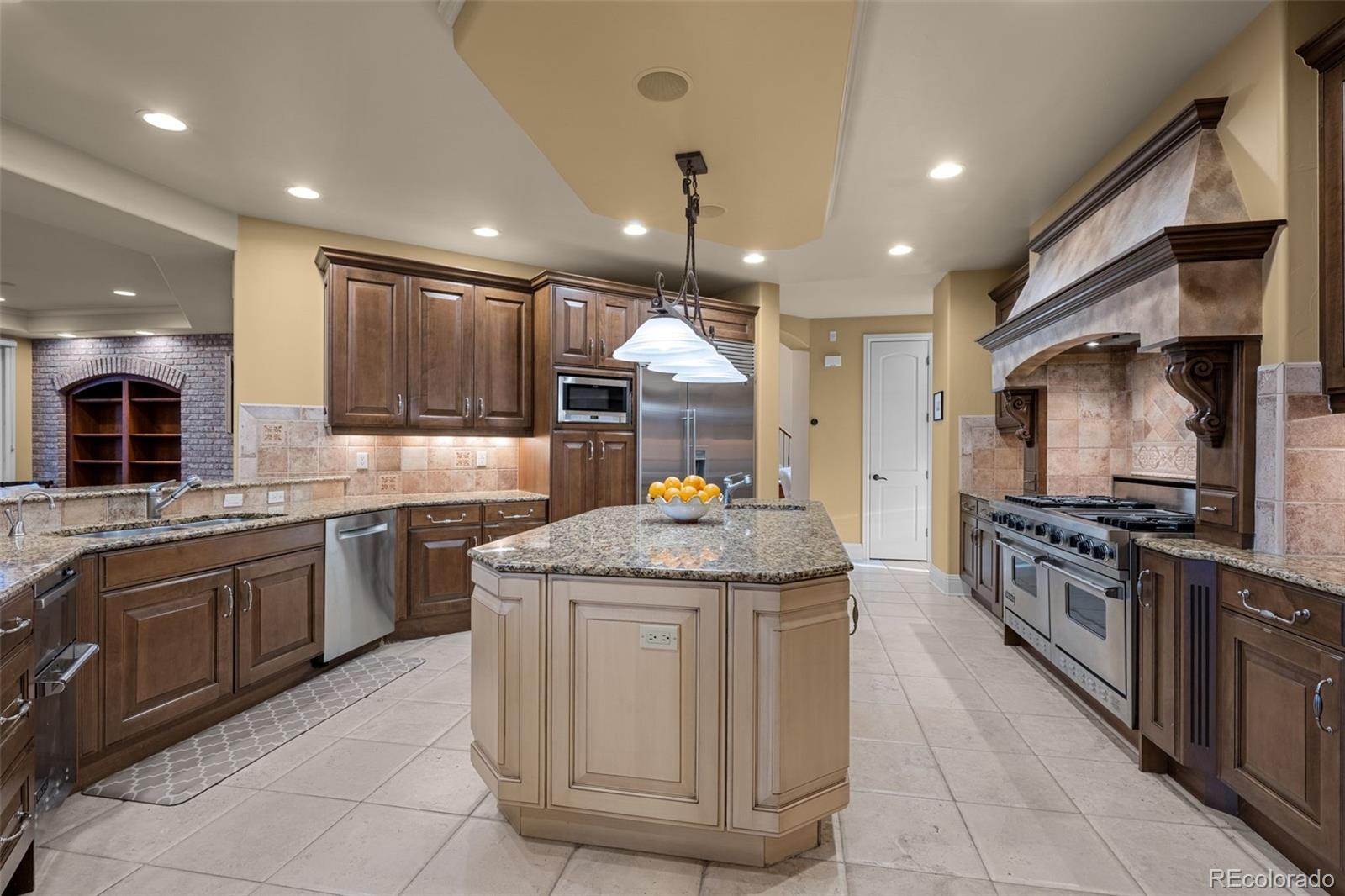 5 Redhawk Run Cherry Hills Village, CO 80113 - Photo 8 of 35 a kitchen with stainless steel appliances granite countertop a sink counter space cabinets and a large window