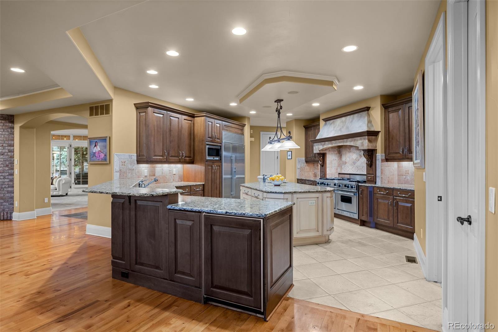 5 Redhawk Run Cherry Hills Village, CO 80113 - Photo 9 of 35 a kitchen with stainless steel appliances granite countertop wooden cabinets a sink a stove a refrigerator and a center island
