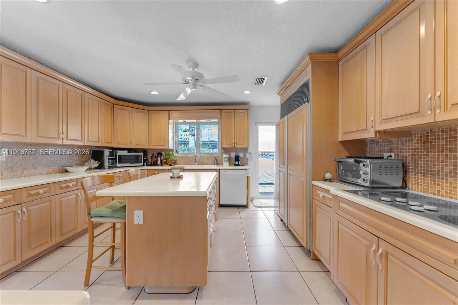 10220 Southwest 140th Street Miami, FL 33176 - Photo 14 of 53 a kitchen with a sink a counter top space stainless steel appliances cabinets and a window