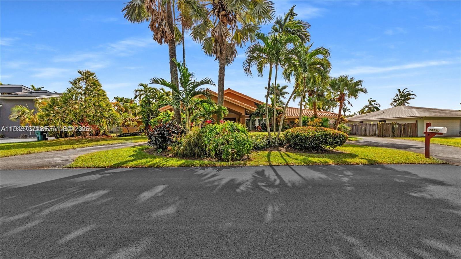 10220 Southwest 140th Street Miami, FL 33176 - Photo 4 of 53 a view of a swimming pool with a yard and palm trees