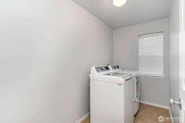 a view of a backyard with wooden fence and a large tree