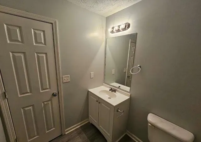 a bathroom with a sink a toilet and mirror