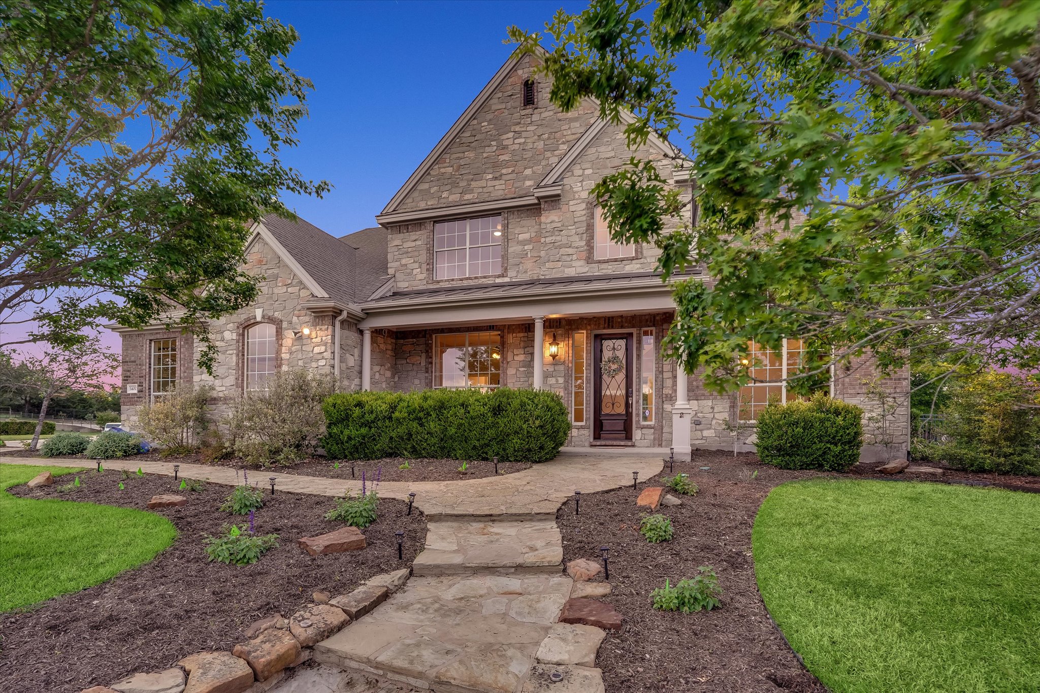 1400 Tom Sawyer Road Austin, TX 78737 - Photo 4 of 40 Classic stone and brick exterior with covered porch and well-maintained grounds.