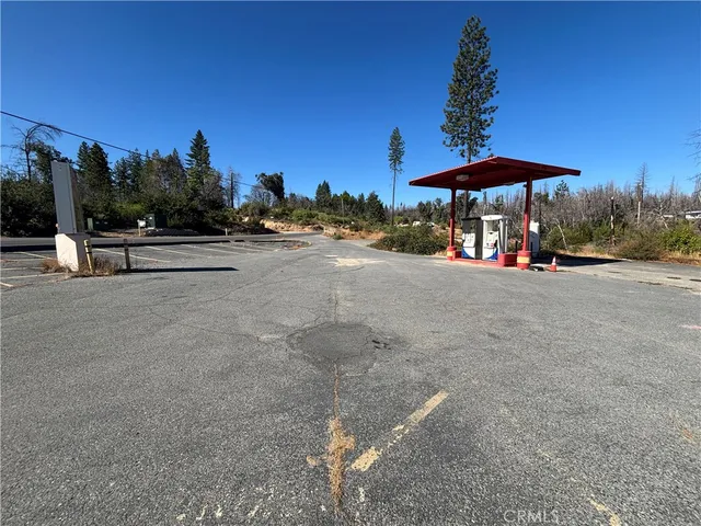a view of patio with a fire pit and trees