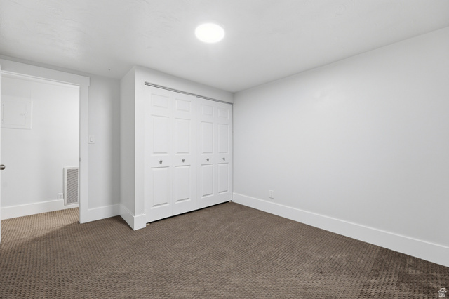 2342 Charros Road Sandy, UT 84092 - Photo 60 of 94 Room featuring a built-in six-panel bifold closet, neutral-toned carpet, and a white ceiling with a flush-mounted light fixture