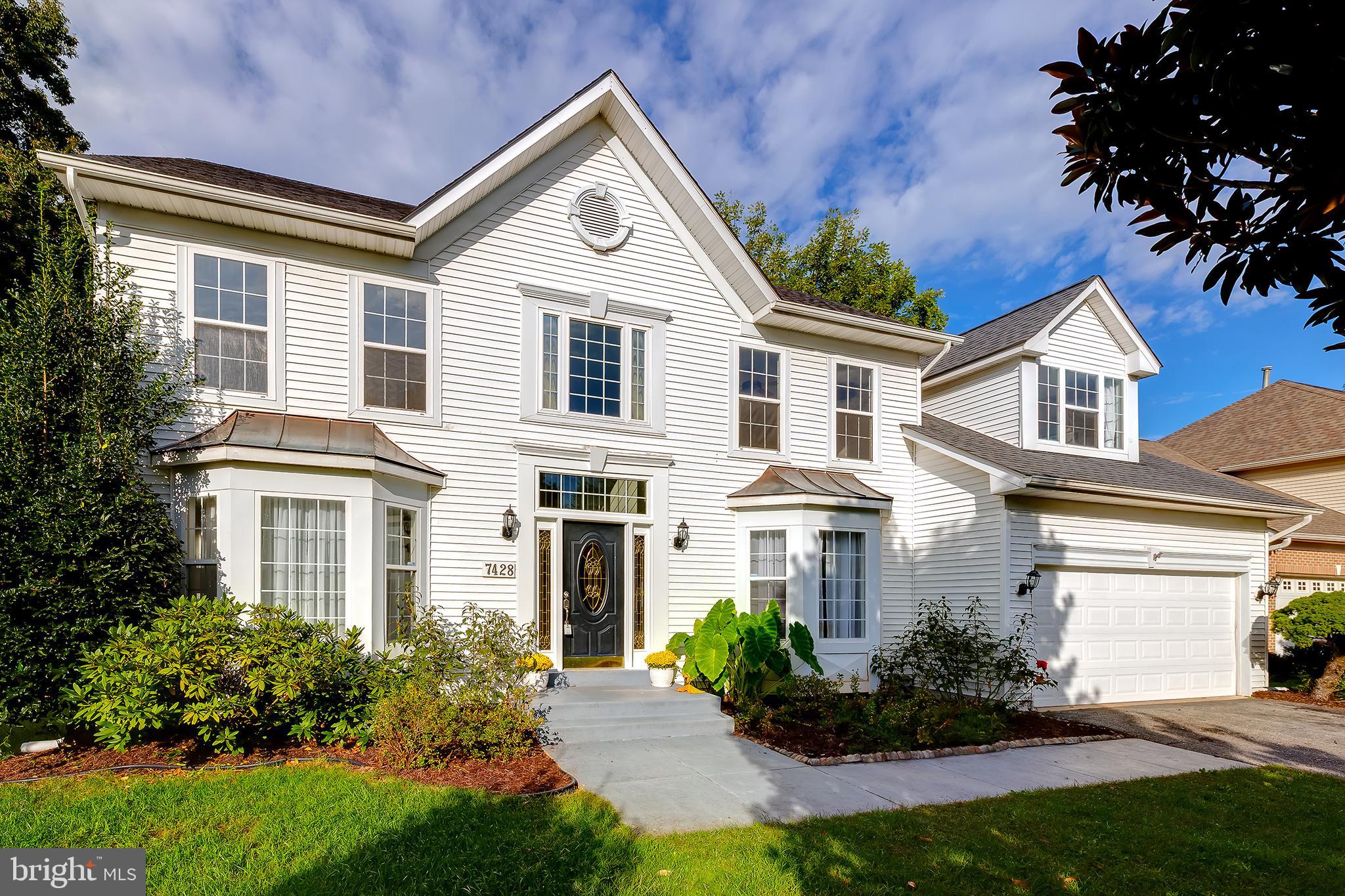 a front view of a house with a garden and plants