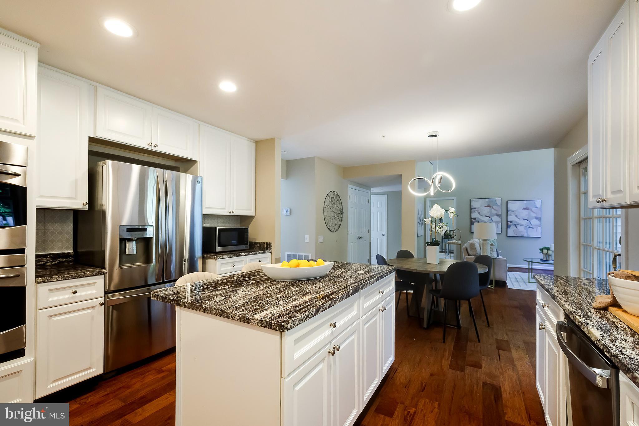 7428 Quail Ridge Lane Bowie, MD 20720 - Photo 27 of 87 a kitchen with granite countertop kitchen island wooden cabinets and stainless steel appliances
