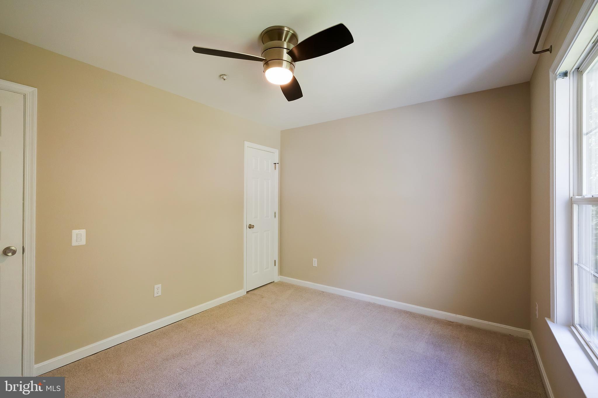 7428 Quail Ridge Lane Bowie, MD 20720 - Photo 61 of 87 an empty room with a window and a ceiling fan