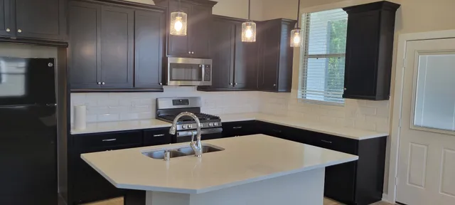 a kitchen with a sink a microwave and cabinets