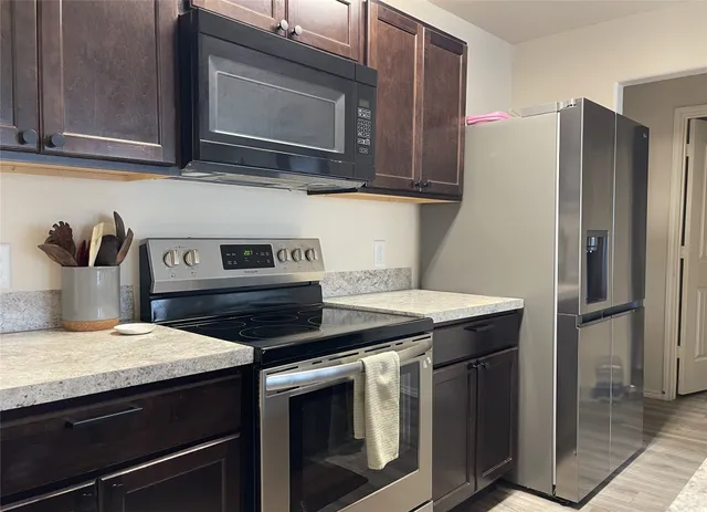 a kitchen with stainless steel appliances granite countertop a stove microwave and refrigerator