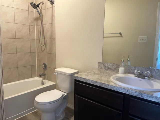 a bathroom with a granite countertop sink toilet and shower