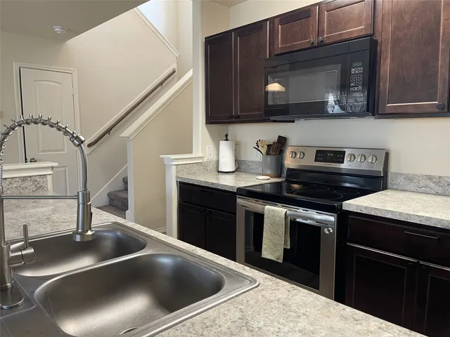 a kitchen with stainless steel appliances granite countertop a sink and a stove