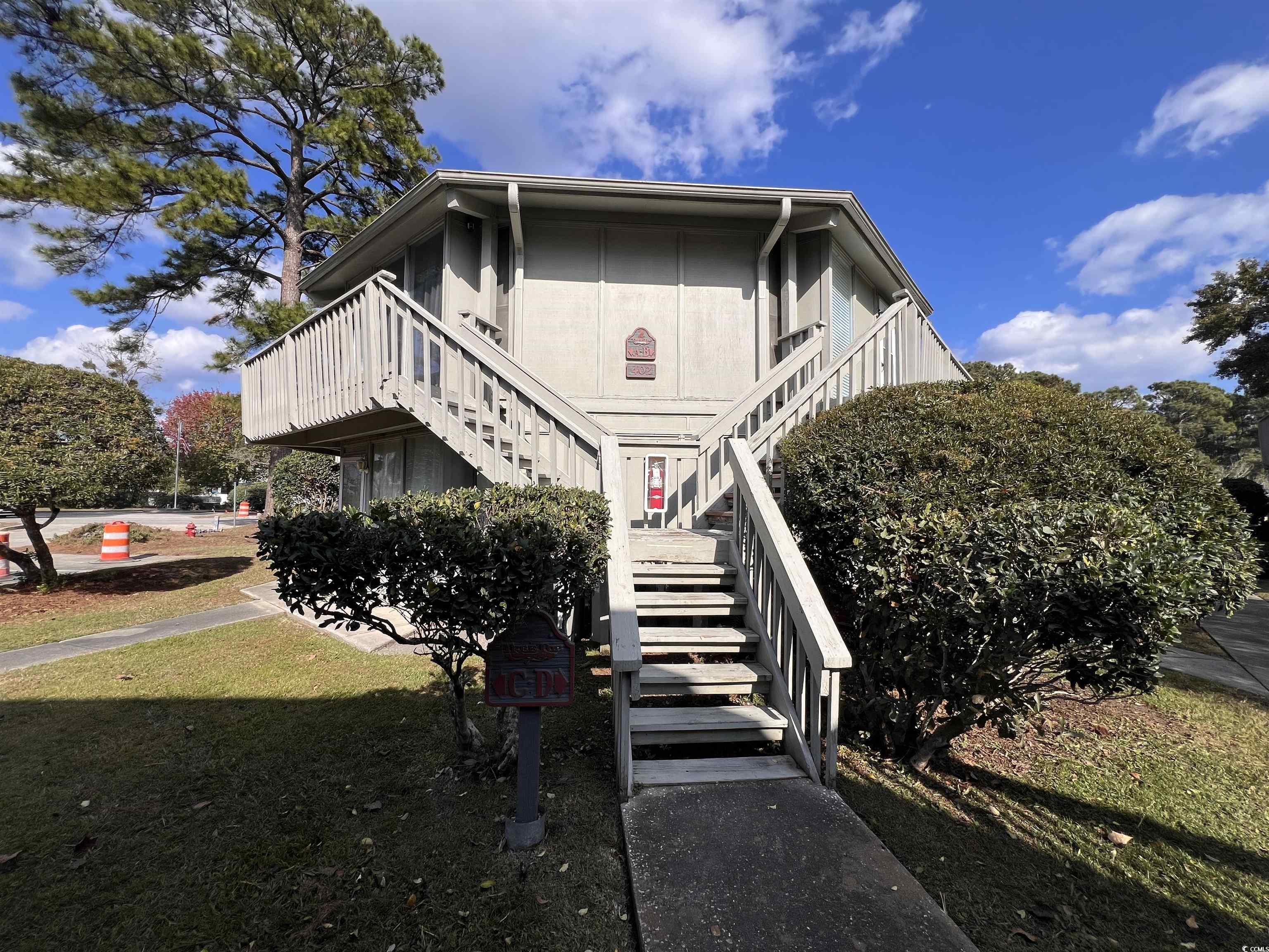 View of property exterior with stairway and a yard