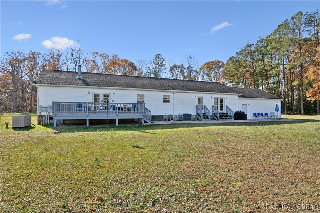 1413 Locust Grove Road Topping, VA 23169 - Photo 42 of 50 Back of property featuring central AC, a yard, a wooden deck, and french doors