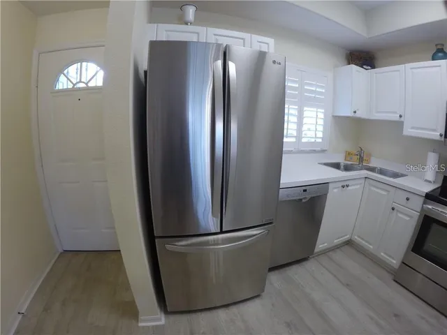 a kitchen with a refrigerator a sink and cabinets