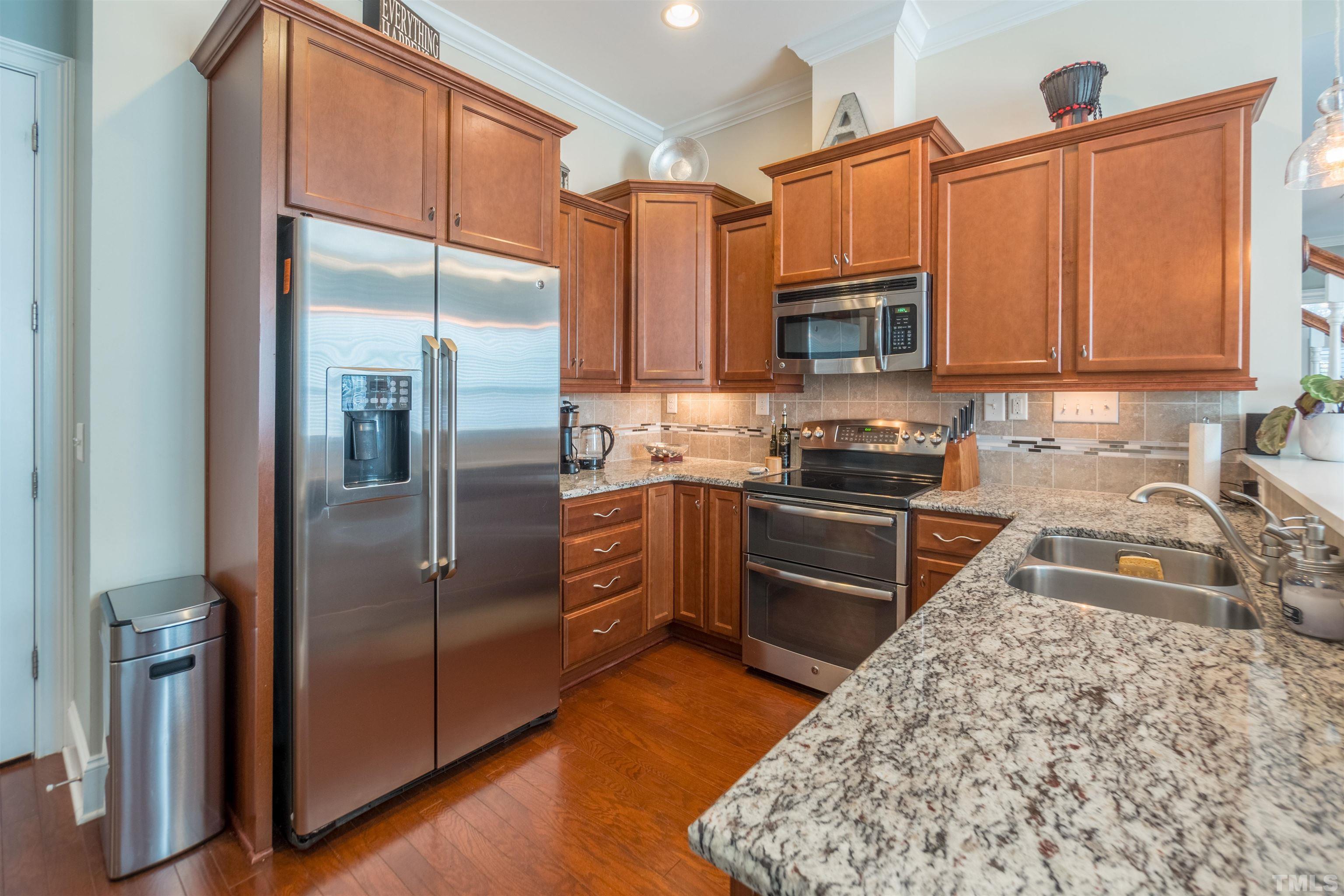 789 Fallon Grove Way Raleigh, NC 27608 - Photo 11 of 29 a kitchen with granite countertop a refrigerator and a sink