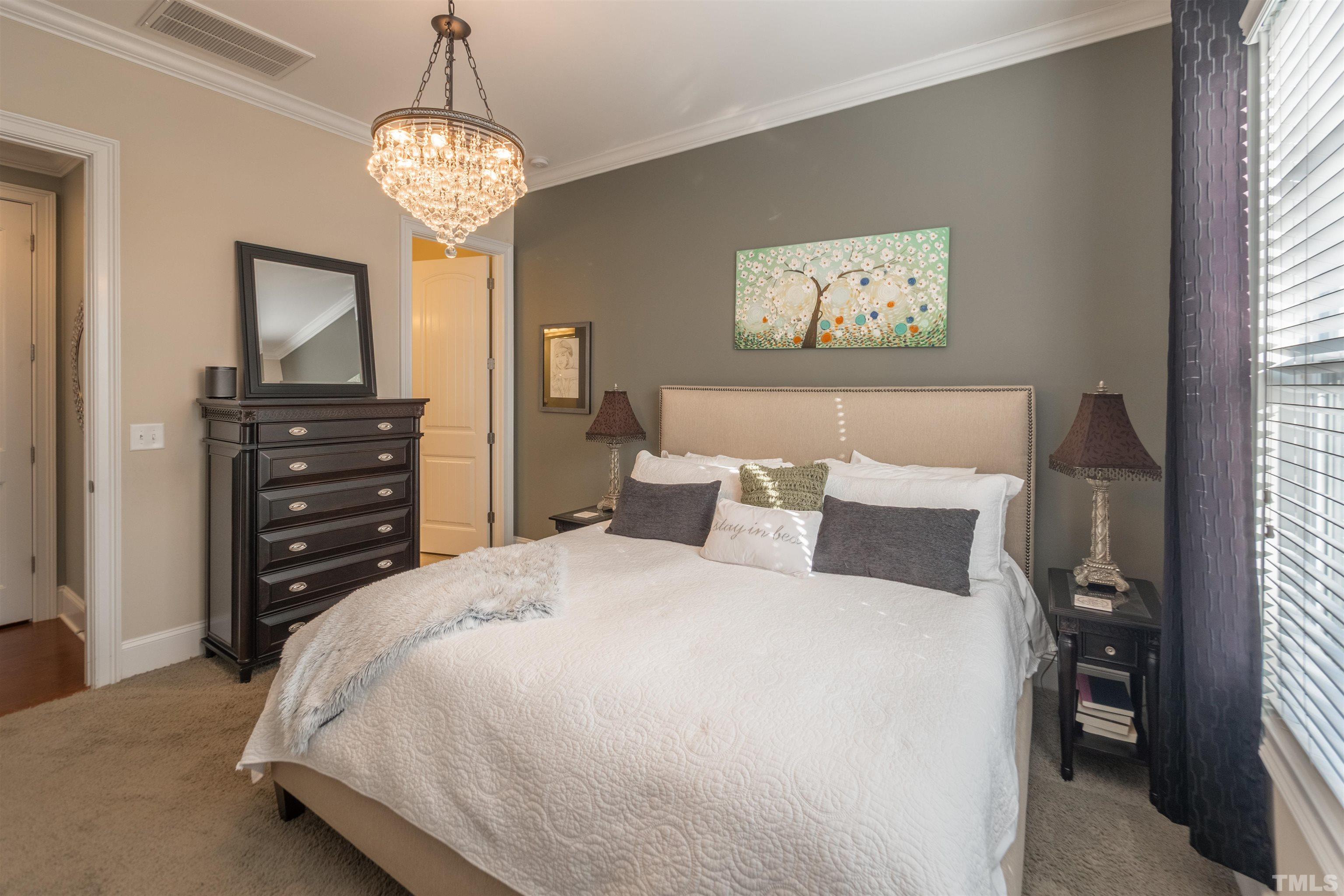 789 Fallon Grove Way Raleigh, NC 27608 - Photo 13 of 29 a bedroom with a bed and a chandelier