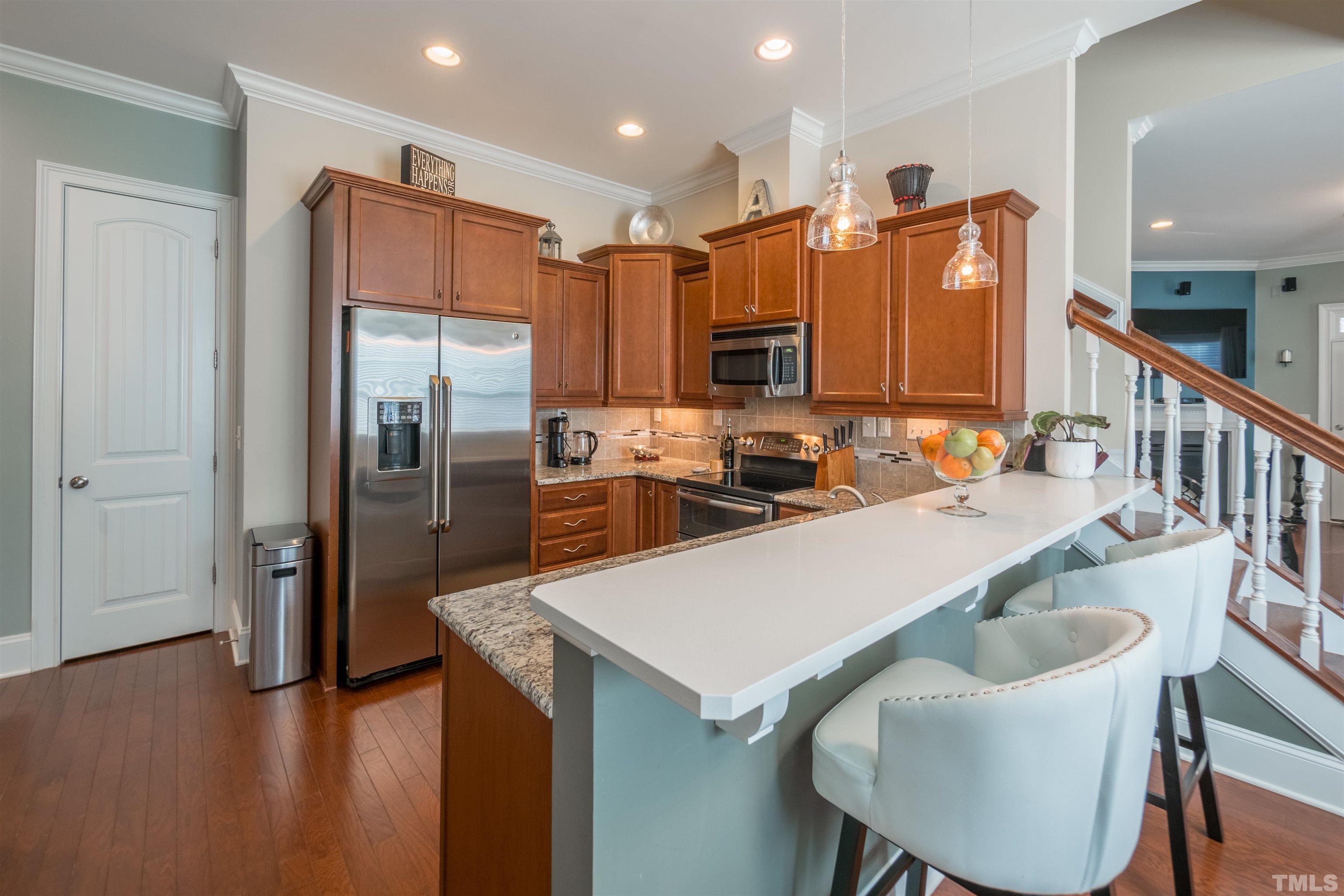 789 Fallon Grove Way Raleigh, NC 27608 - Photo 9 of 29 a kitchen with stainless steel appliances granite countertop a sink a refrigerator and a stove