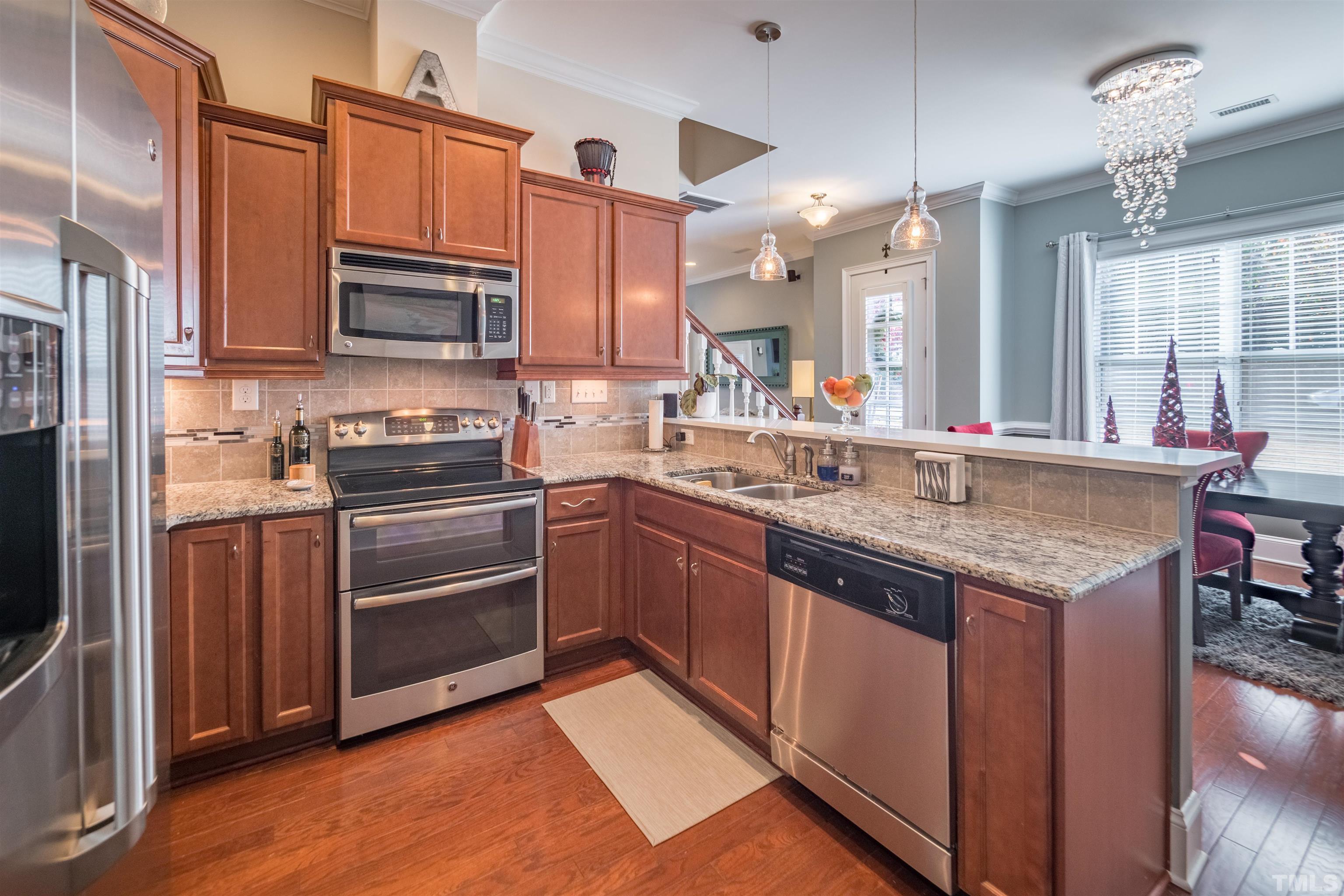 789 Fallon Grove Way Raleigh, NC 27608 - Photo 10 of 29 a kitchen with stainless steel appliances granite countertop a sink stove and refrigerator