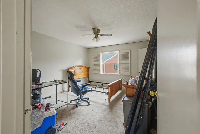 a view of a workspace with furniture and a window