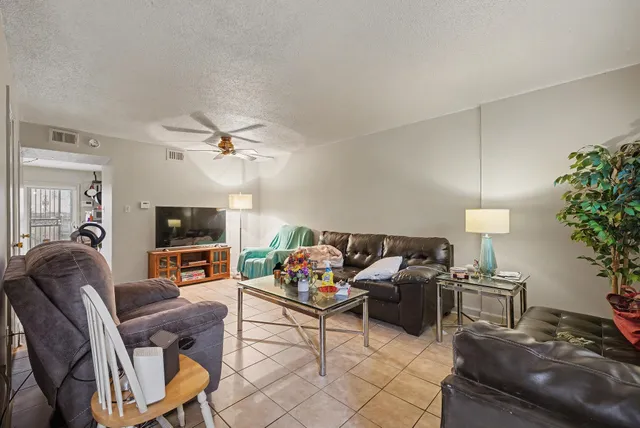 a living room with furniture a flat screen tv and a potted plant