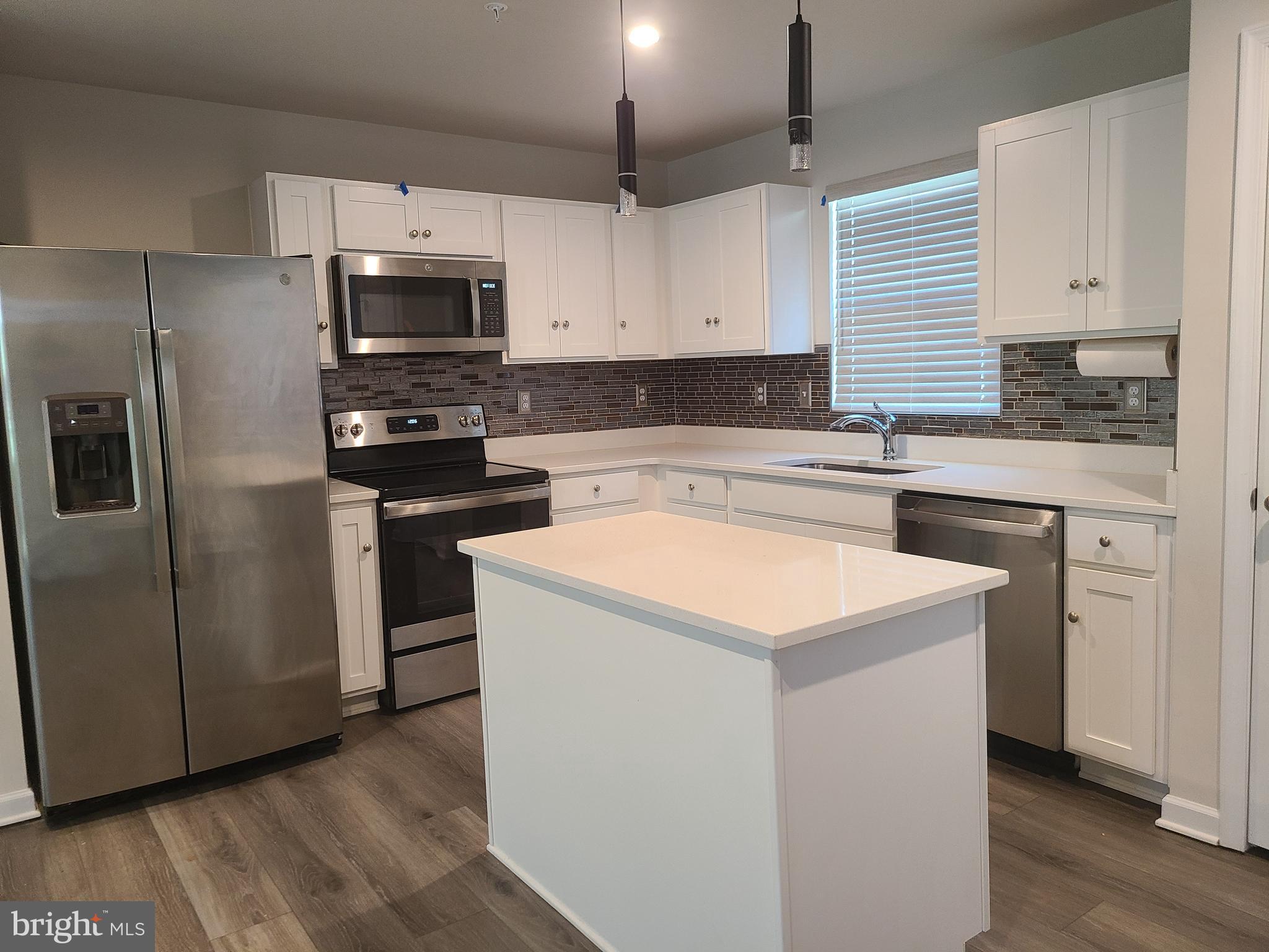 105 Mariners Way Cambridge, MD 21613 - Photo 4 of 45 a kitchen with stainless steel appliances a stove a sink a refrigerator and white cabinets