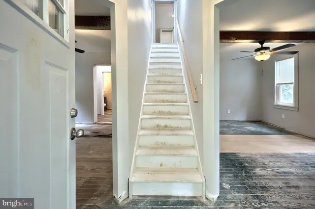 an empty room with fan and windows