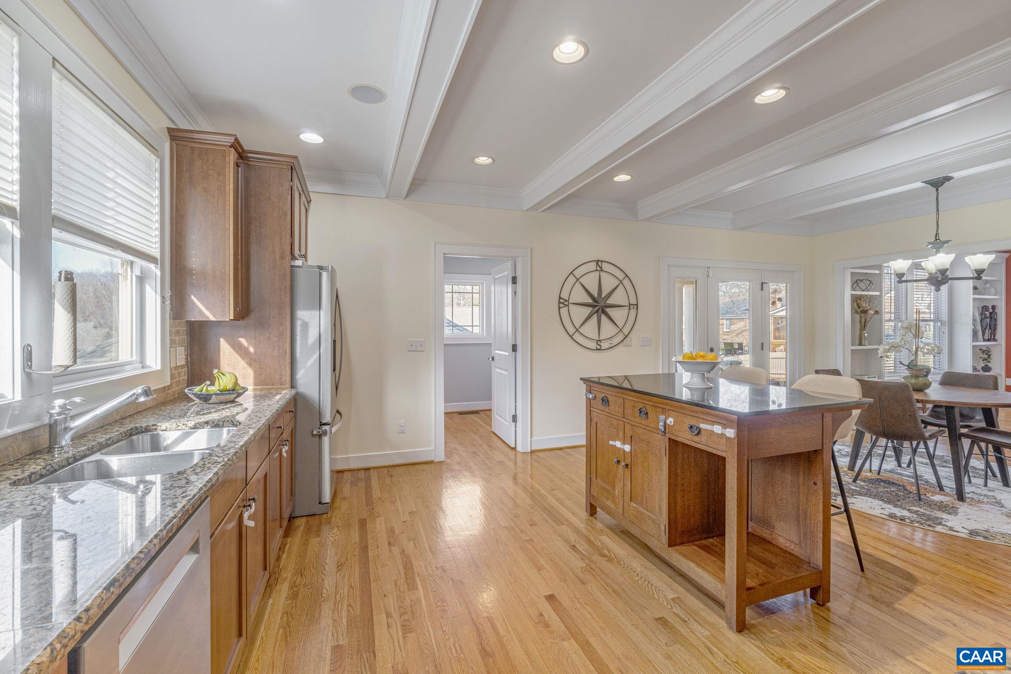 811 Village Road Charlottesville, VA 22903 - Photo 14 of 66 a kitchen with stainless steel appliances granite countertop a stove top oven a refrigerator a dining table and chairs with wooden floor