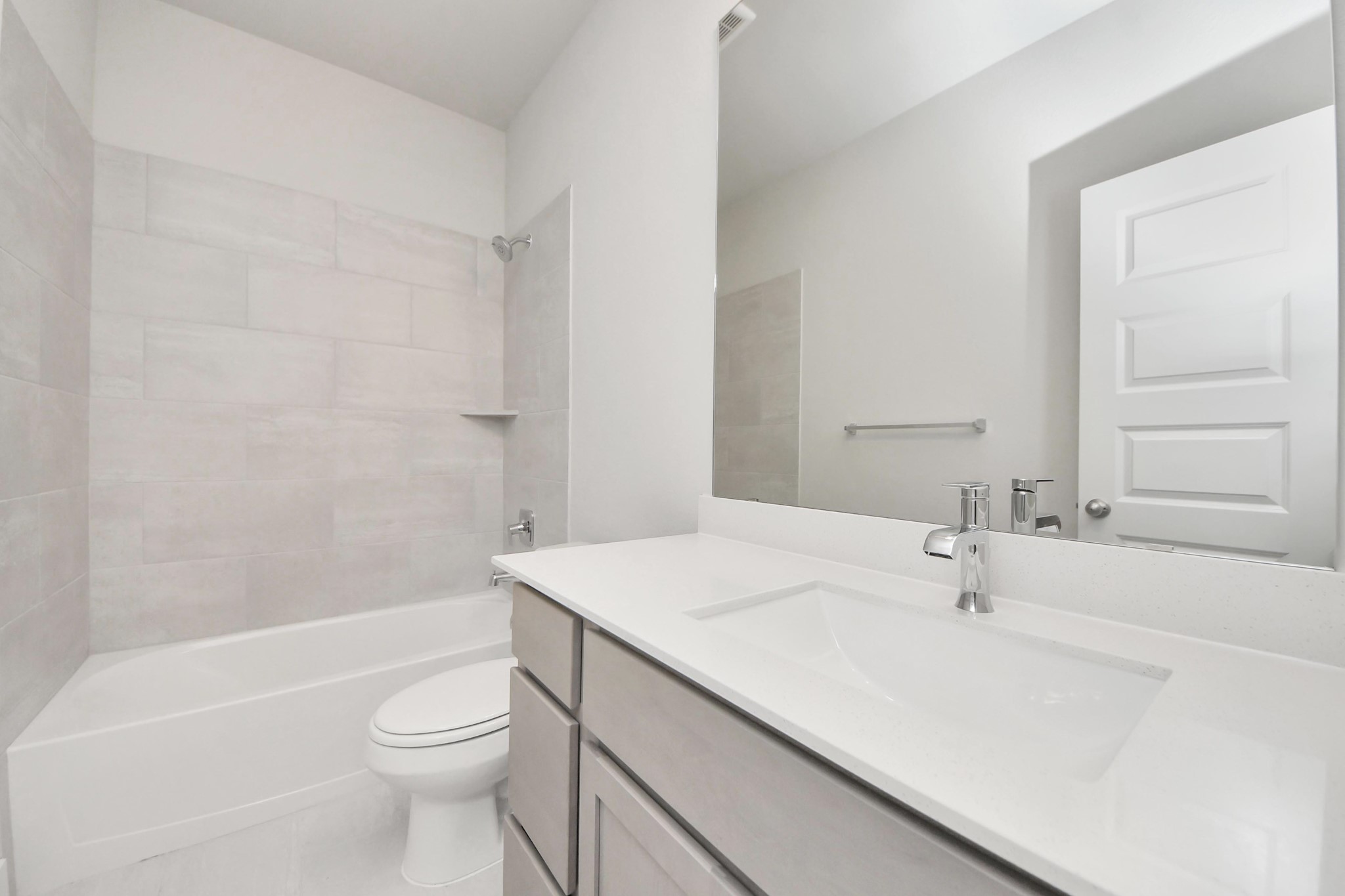 3042 Native Spg Drive Spring, TX 77373 - Photo 10 of 32 Secondary bath features tile flooring, bath/shower combo with tile surround, light stained wood cabinets, beautiful light countertop. Sample photo of completed home with similar floor plan. Actual colors and selections may vary.