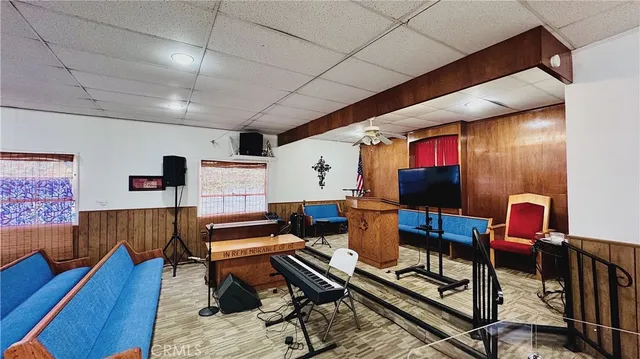 a living room with furniture a flat screen tv and kitchen view