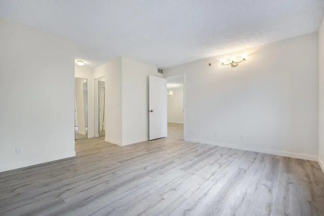 a view of an empty room with wooden floor