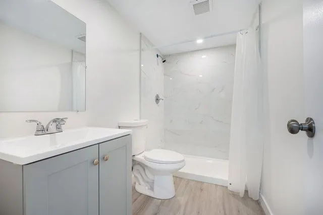 a bathroom with a sink a toilet and shower