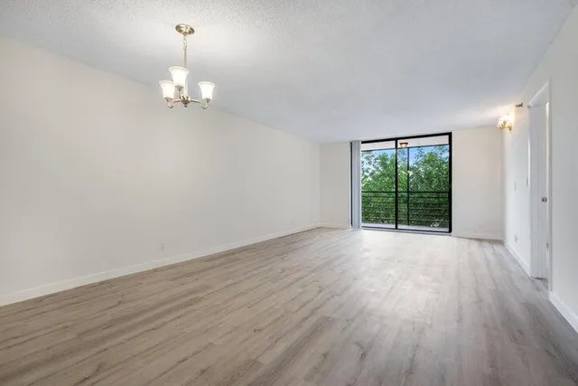 an empty room with wooden floor and window
