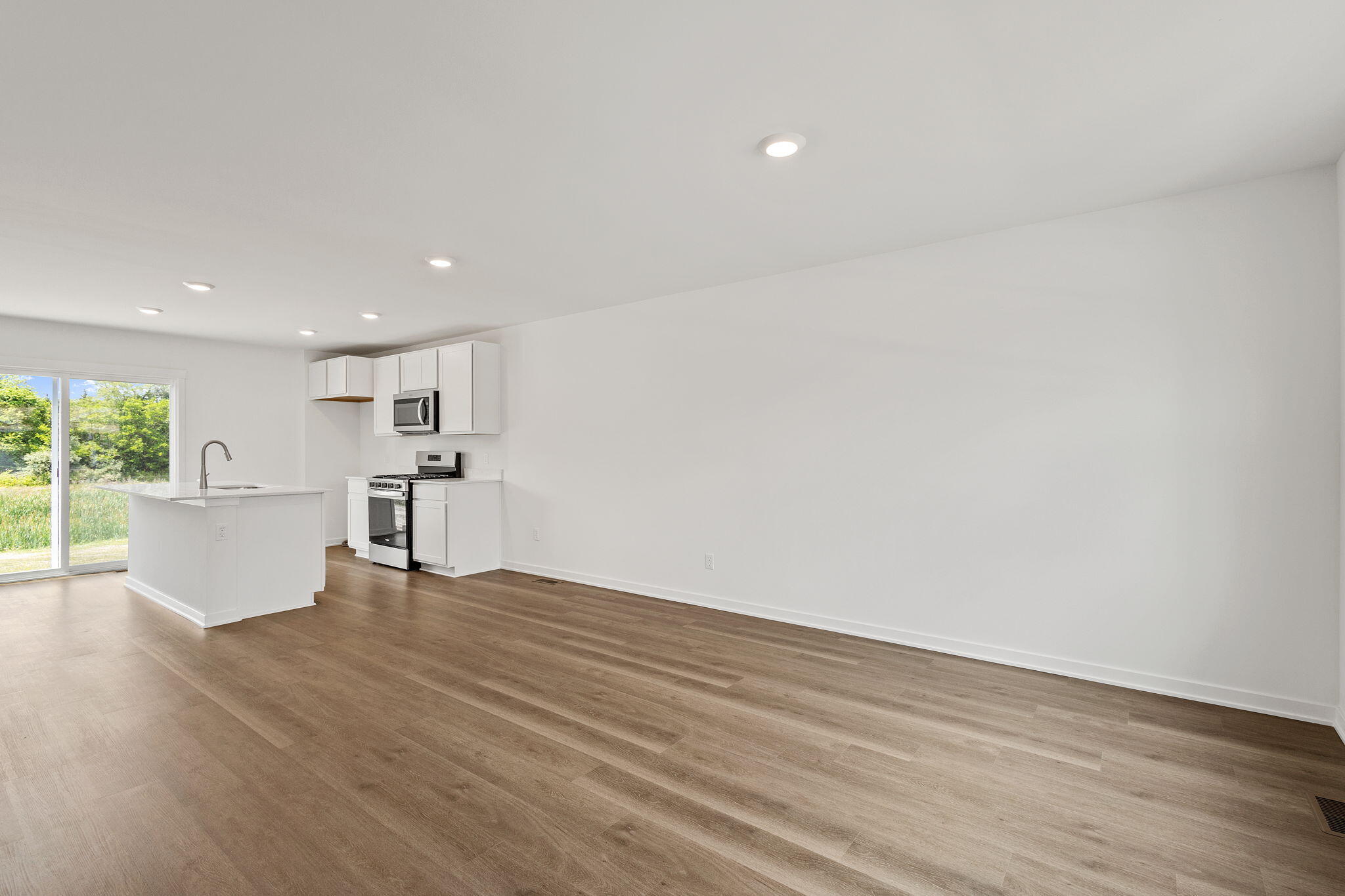 594 Petry Street Hebron, IN 46341 - Photo 6 of 18 a view of kitchen with wooden floor and windows