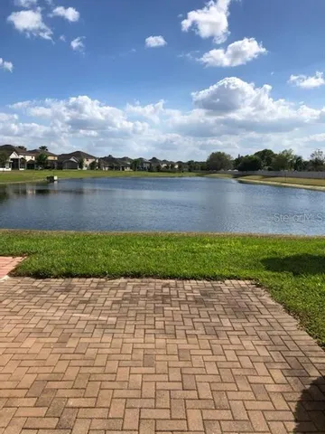 a front view of a house with a garden and trees