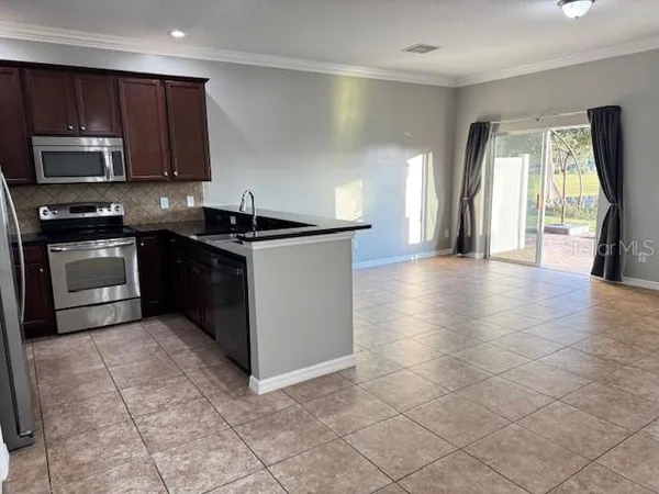 a kitchen with stainless steel appliances granite countertop a stove a sink and a microwave