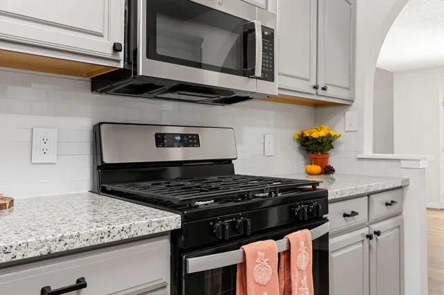 a kitchen with stainless steel appliances granite countertop a stove and a microwave