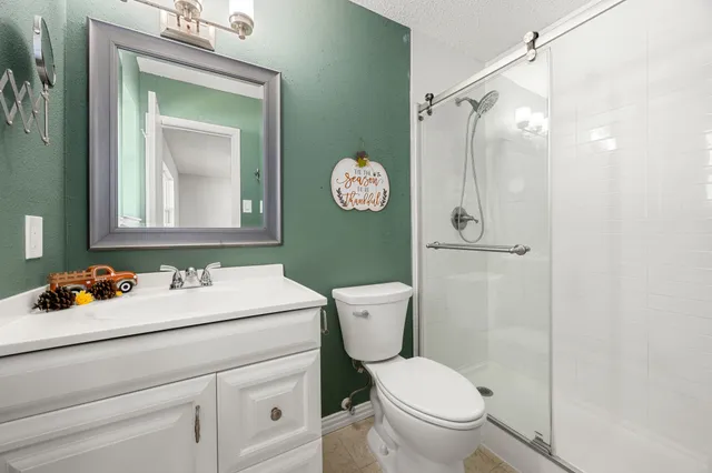 a bathroom with a toilet sink vanity and mirror