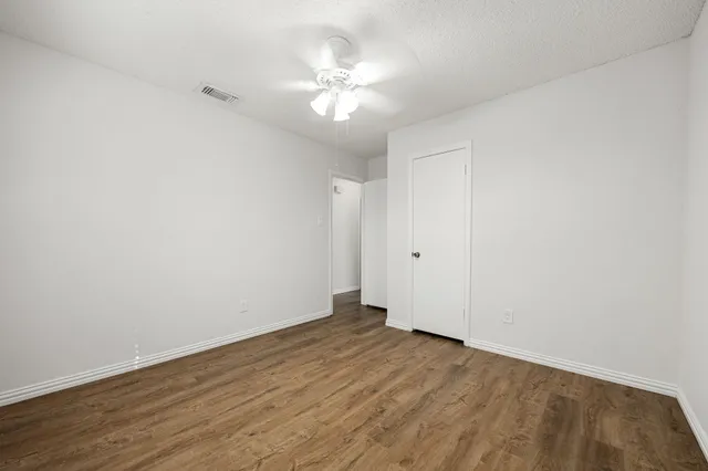 a view of an empty room with wooden floor