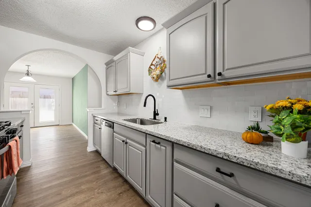 a kitchen with stainless steel appliances granite countertop a sink and cabinets