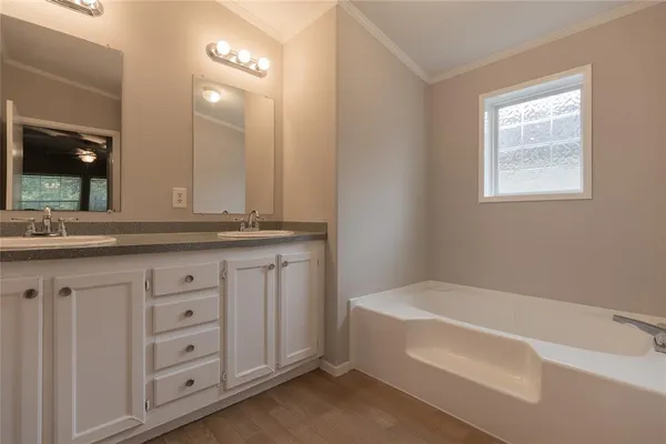 a bathroom with a bathtub a sink a vanity and a window