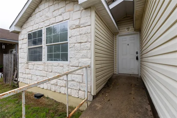 a view of house with wooden stairs and door