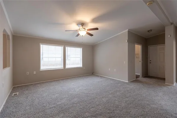 a view of a room with a ceiling fan and a window
