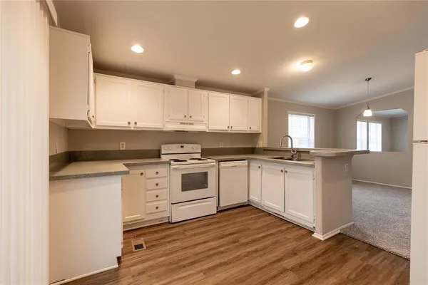 a kitchen with wooden floors and white appliances