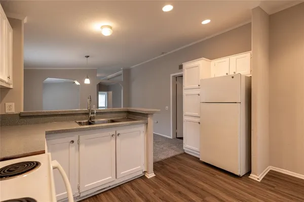 a kitchen with granite countertop a refrigerator a sink and dishwasher