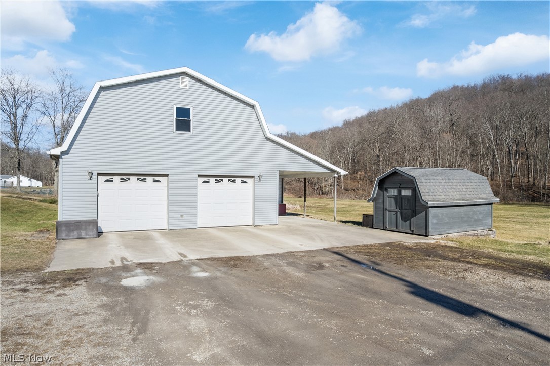 29395 Beitler Road Dennison, OH 44621 - Photo 3 of 33 View of home's exterior with a gambrel roof, a shed, driveway, and a yard