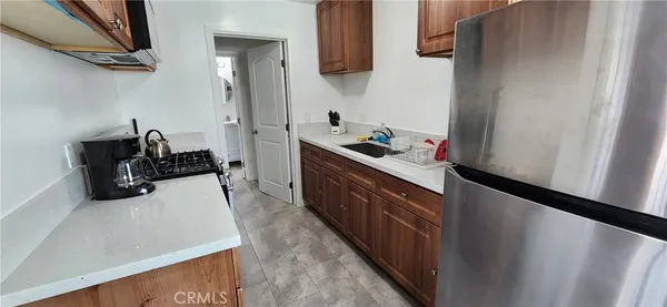 a kitchen with stainless steel appliances granite countertop a refrigerator a sink and a stove