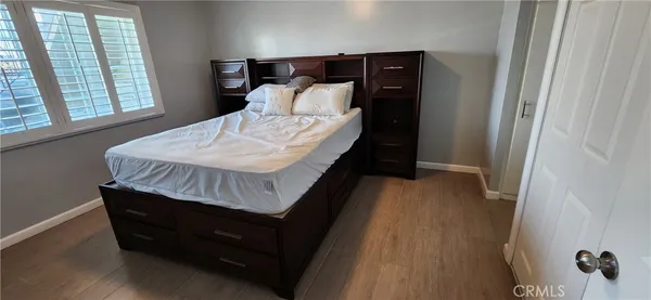 a bedroom with a bed and wooden floor