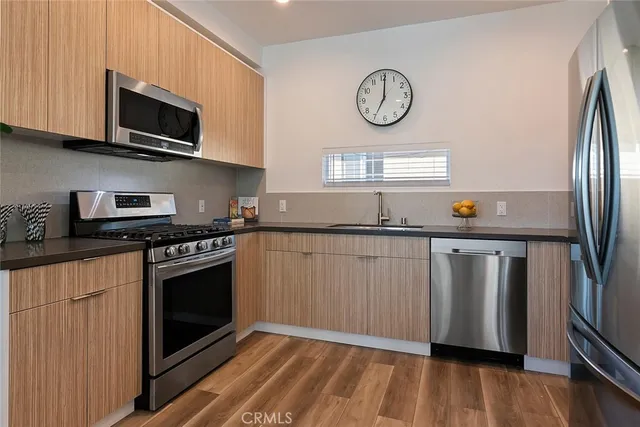 a kitchen with stainless steel appliances granite countertop a stove a microwave and a refrigerator